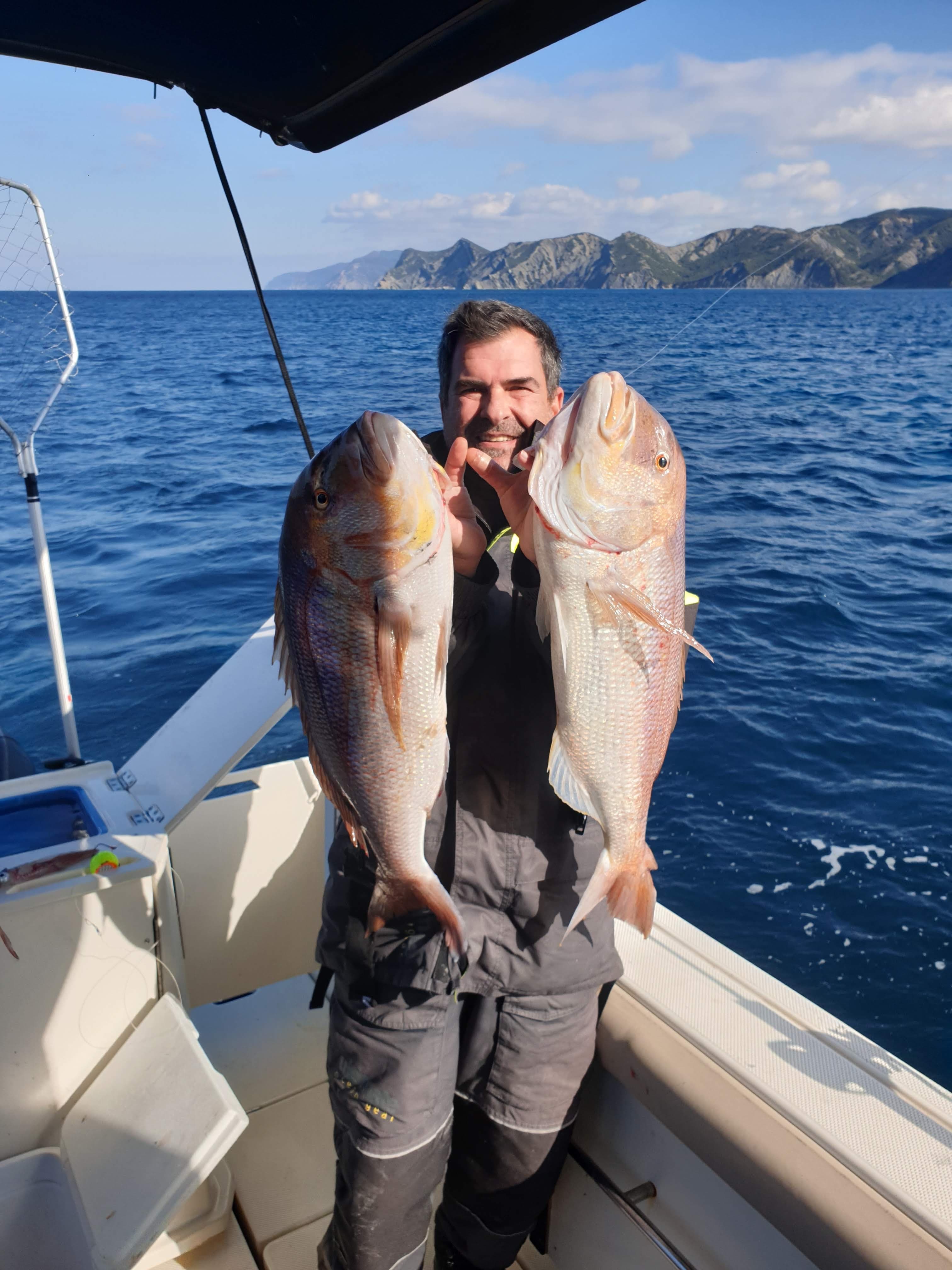 Captain holding two trophy fish